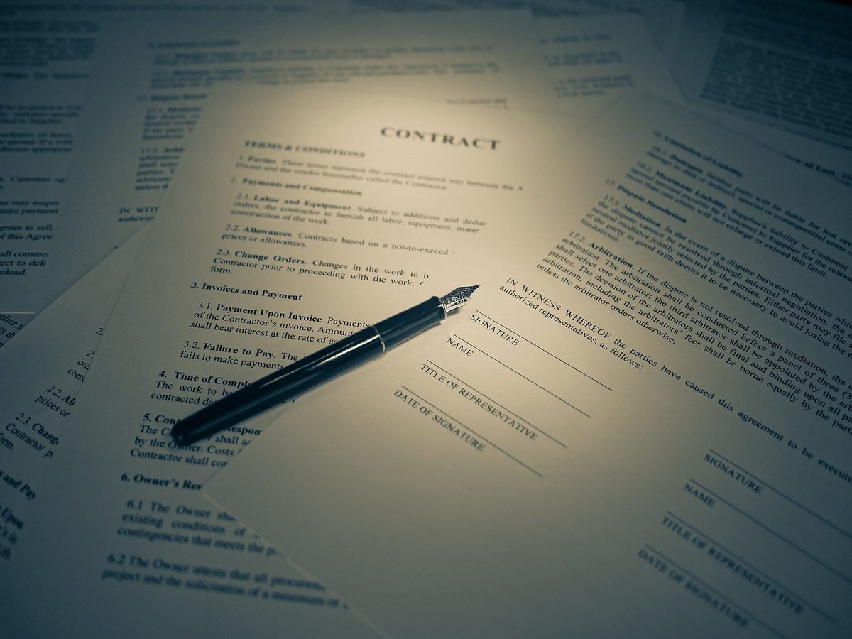 A contract with signature lines and a fountain pen